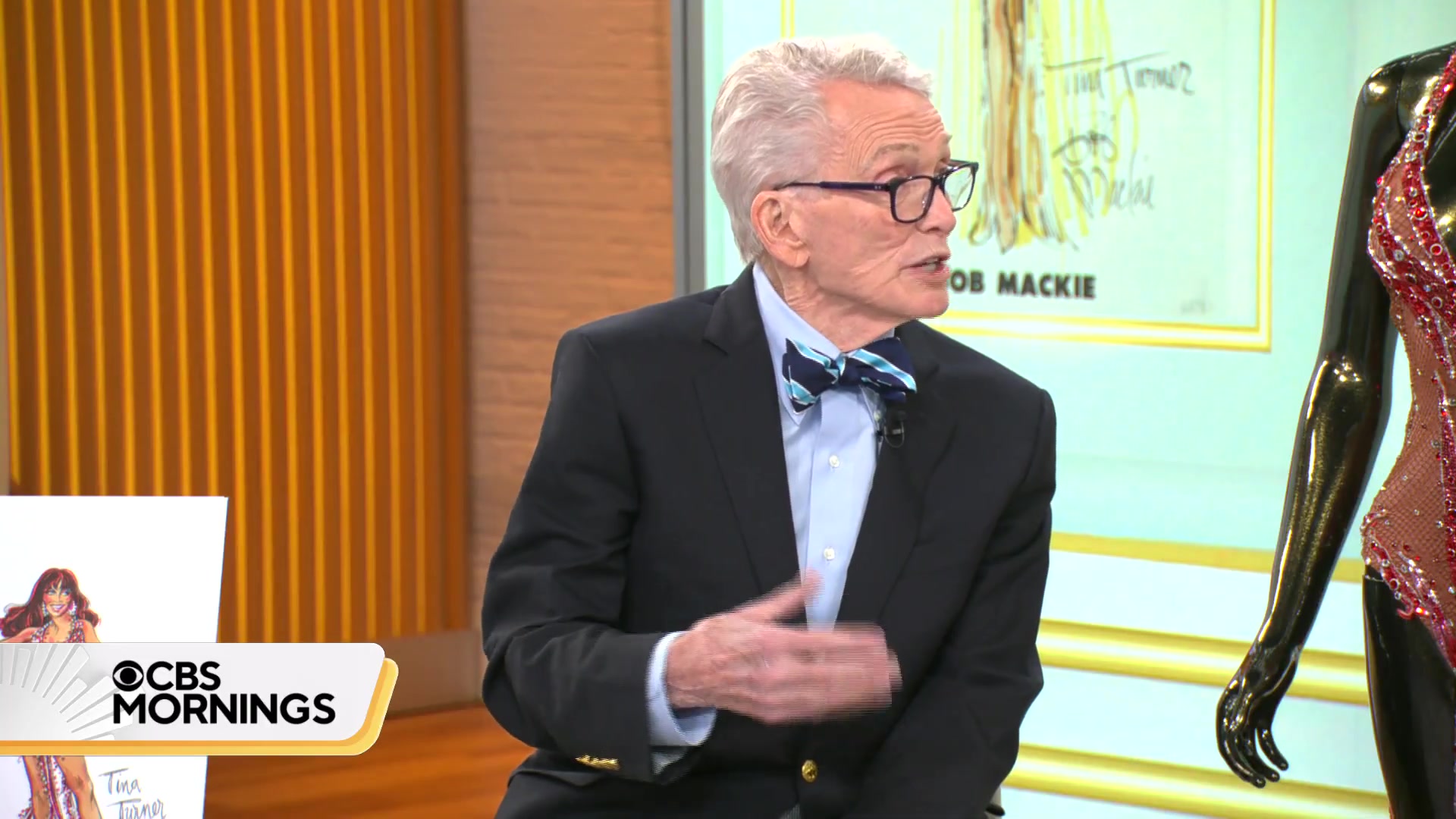 Bob Mackie naast een van zijn kostuums en een schets voor Tina Turner