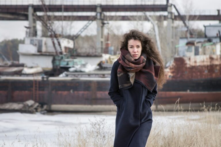 Vrouw in een lange marineblauwe wollen jas op straat