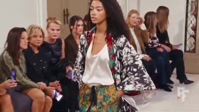 Model in een kimonojasje en een broek met bloemenprint op de catwalk van Alberta Ferretti in Milaan