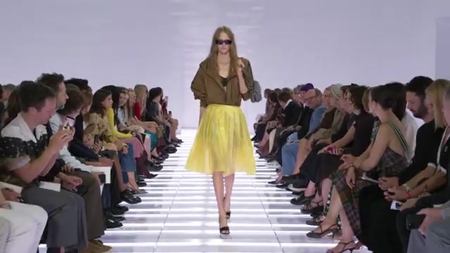 Model op de catwalk van Prada in een gele rok en pumps, show lente 2027