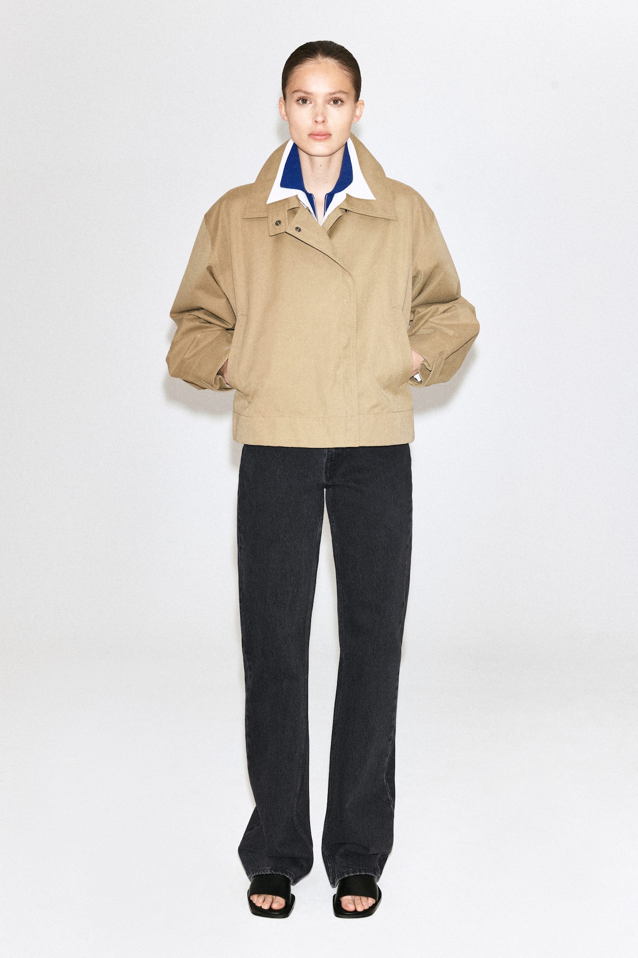 Beige korte trenchcoat met gebogen mouwen en een grote kraag