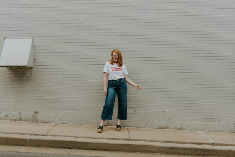 Wijde jeans met zwarte ballerina's op een stoep