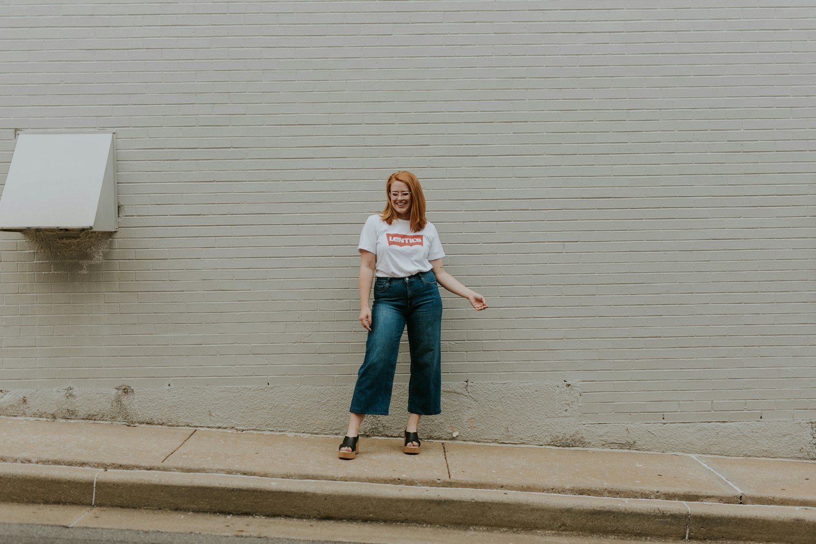 Wijde jeans met zwarte ballerina's op een stoep