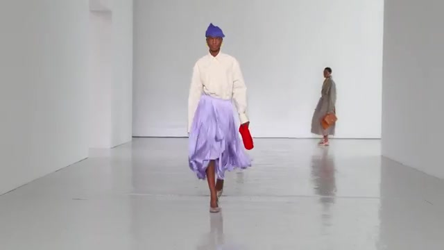 Model in een crèmekleurige trui en lila rok met rode tas op de catwalk van Bottega Veneta voor lente 2027
