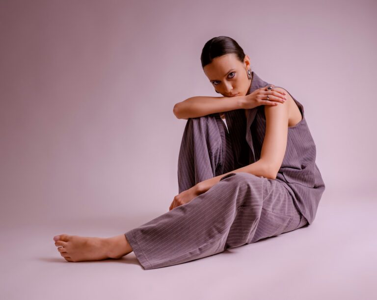 Vrouw in een grijze wijde pantalon met een trui en loafers