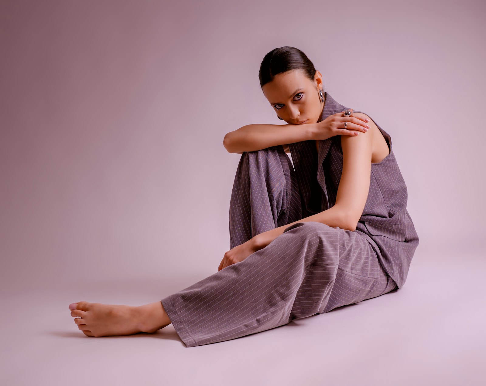 Vrouw in een grijze wijde pantalon met een trui en loafers