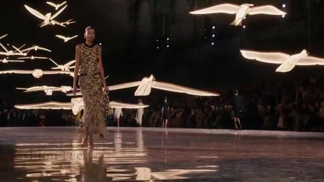 Model op de catwalk van Chanel lente 2027 onder verlichte zwaluwen in het Grand Palais, uit een video van Fashion Feed