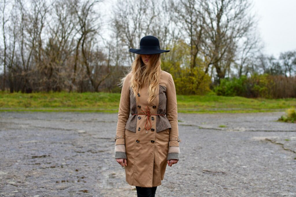 Vrouw in een beige trenchcoat op een natte straat in de stad