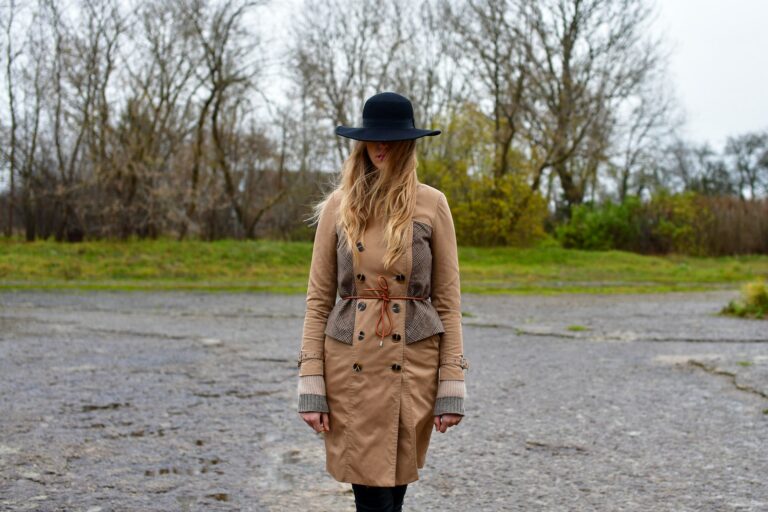Vrouw in een beige trenchcoat op een natte straat in de stad