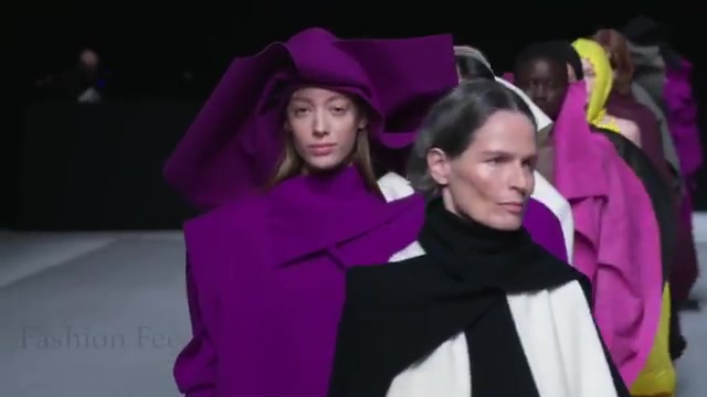 Modellen in ruime gewikkelde jassen in paars, wit en roze bij de finale van Issey Miyake herfst en winter 2026, uit een video van Fashion Feed