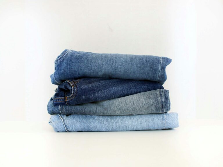 Stapel jeans in verschillende wassingen op een tafel
