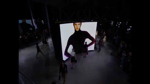 Modellen op de catwalk van Alaïa lente zomer 2027 langs grote videoschermen, uit de film van Maison Alaïa