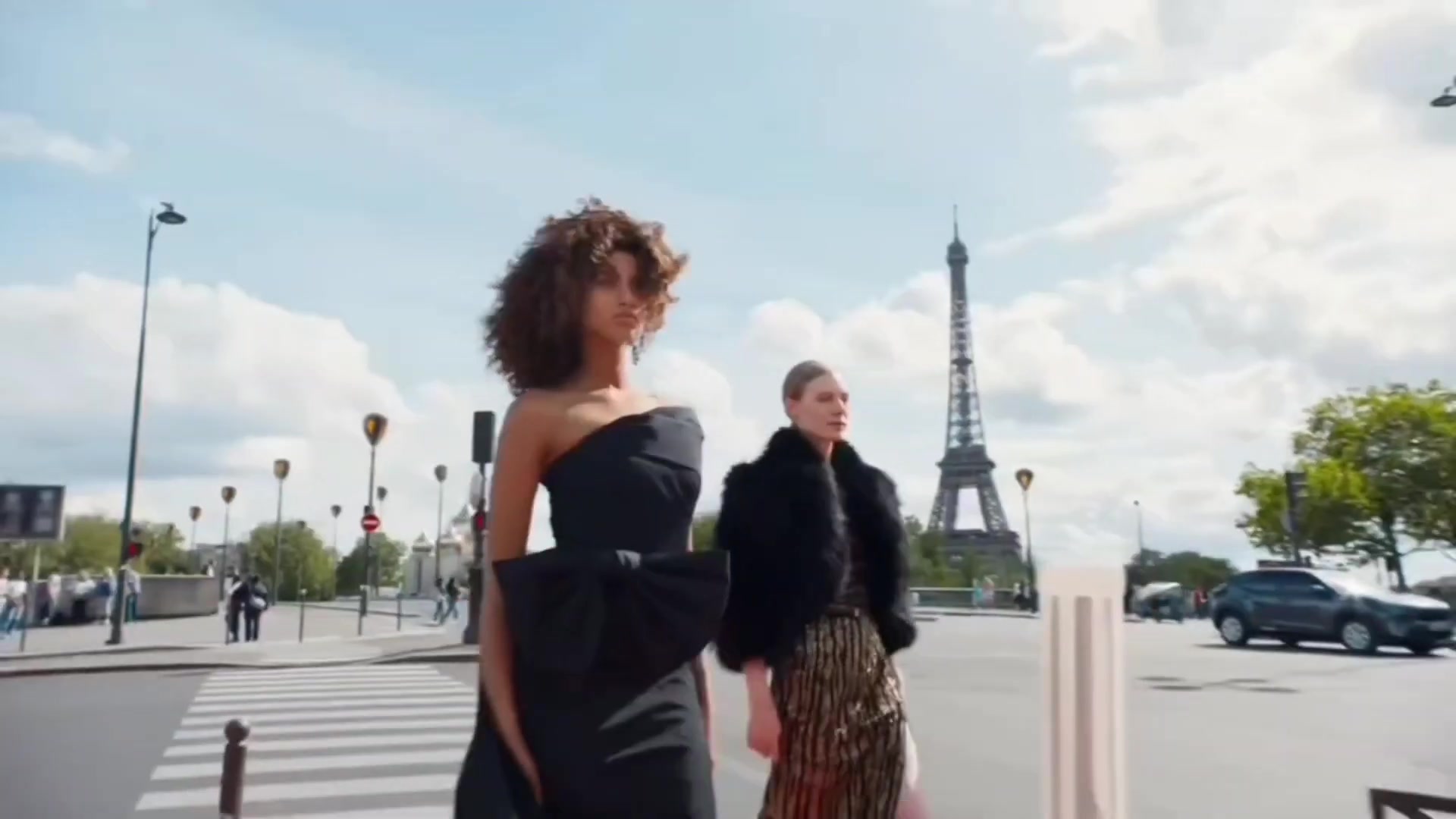 Twee modellen in zwarte avondkleding uit de collectie van Elie Saab voor H&M bij de Eiffeltoren
