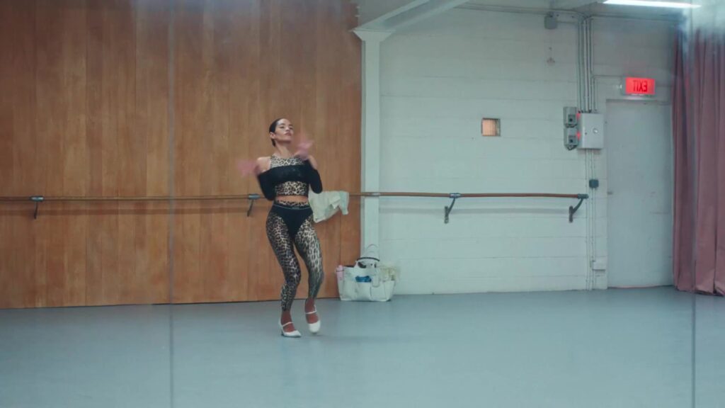 Danseres in luipaardprint legging en top uit de collectie van Ganni en Lululemon in een dansstudio
