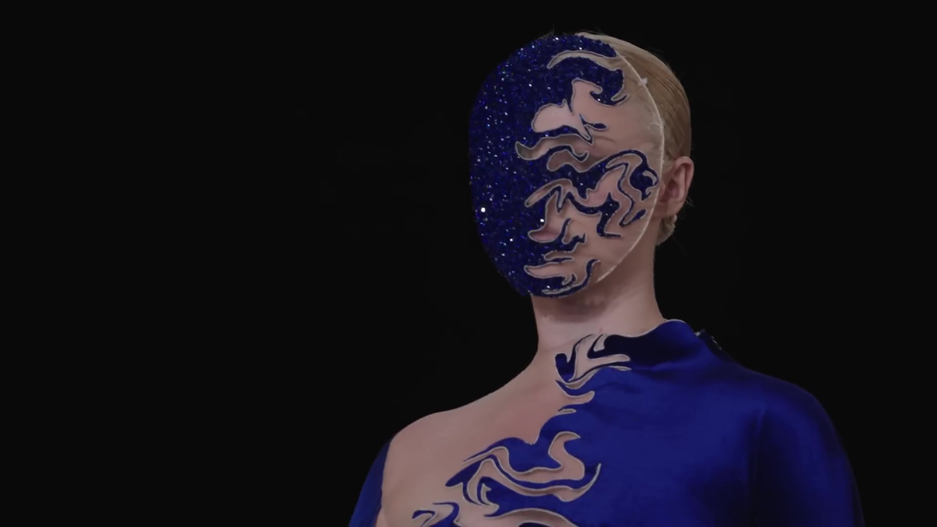 Model in een kobaltblauwe look met glinsterend masker van Iris van Herpen