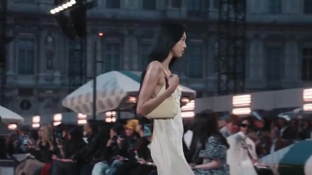 Model in een lichte crèmekleurige slipdress met schoudertas op de catwalk van Louis Vuitton voor lente 2027 in Parijs, uit de officiële showvideo