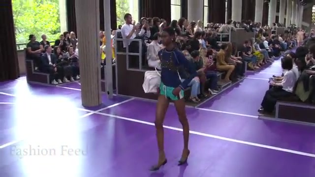 Model in een sportief jack en shorts op de paarse catwalk van Miu Miu