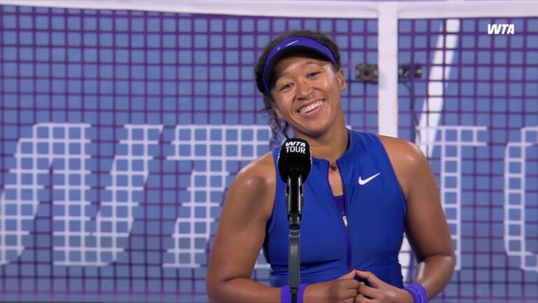 Naomi Osaka in een blauwe tennisjurk na haar overwinning in Tokio