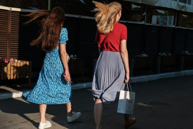 Vrouw in een lange geplisseerde rok met een trui en laarzen