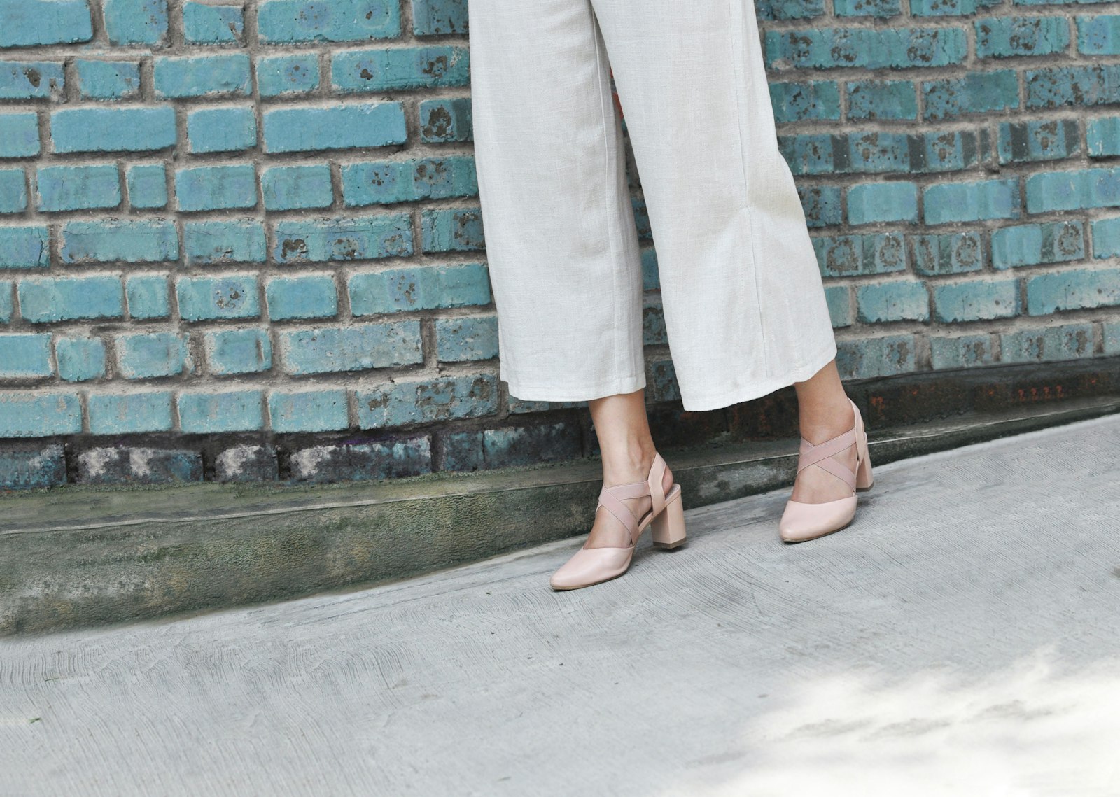 Vrouw in een lange wijde jeans die op haar schoenen valt
