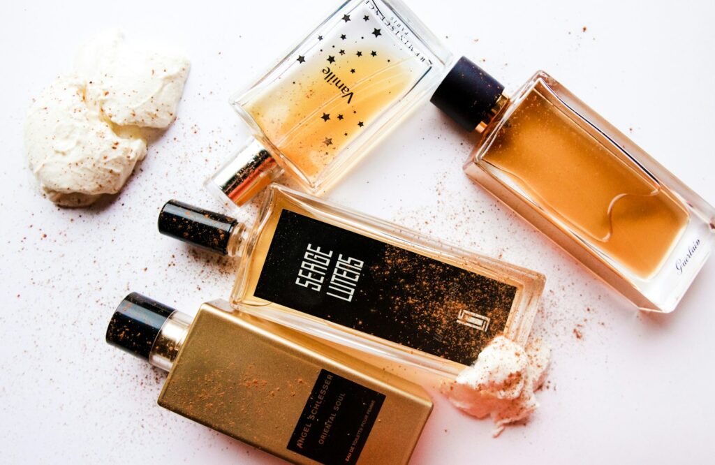 Parfumflesjes met vanillestokjes op een houten tafel