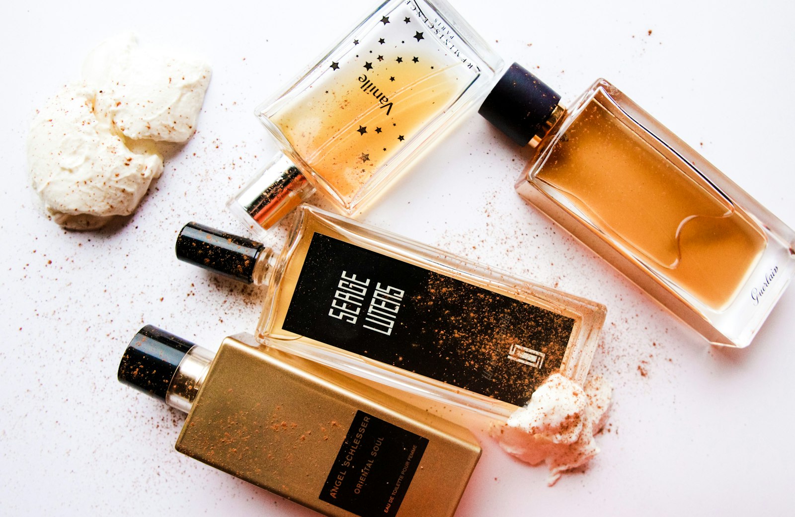 Parfumflesjes met vanillestokjes op een houten tafel