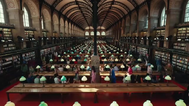 Modellen lopen tussen de leestafels van de Bibliothèque Sainte-Geneviève tijdens de Valentino-show voor lente 2027, uit een video van Fashion Feed