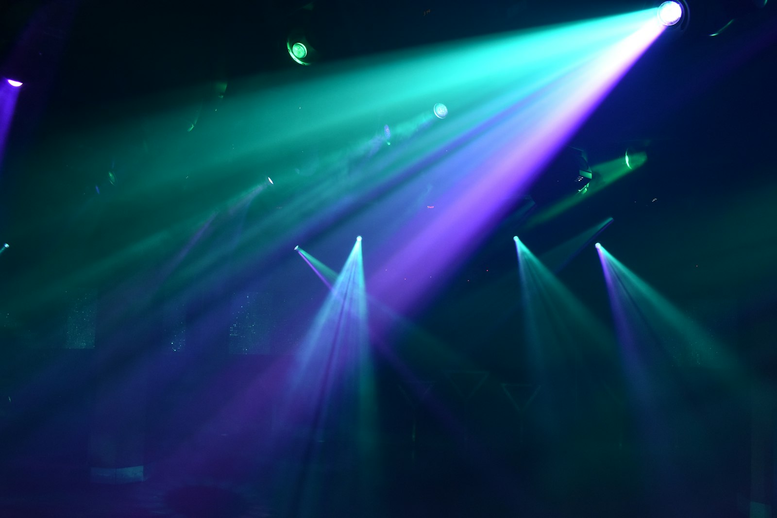 Mensen dansen in een donkere club met lichtstralen boven de dansvloer