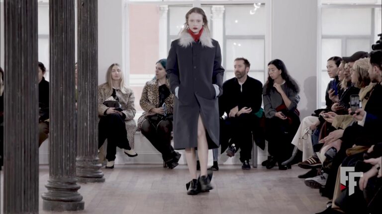 Model in een lange grijze jas op de catwalk van Lii tijdens de modeweek van New York