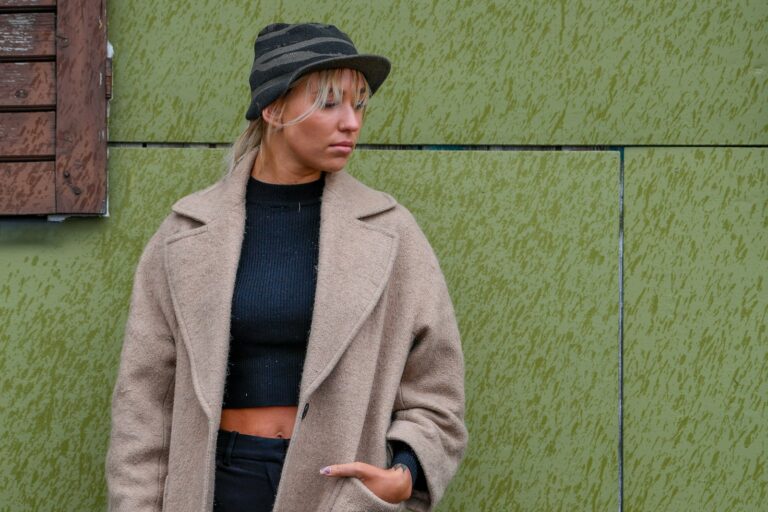 Vrouw in een lange wollen mantel op straat in de herfst